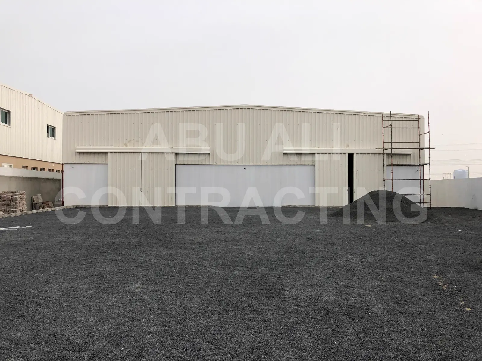 Completed pre-engineered steel warehouse exterior at Al Ttay, Dubai with insulated wall cladding and roller shutter openings