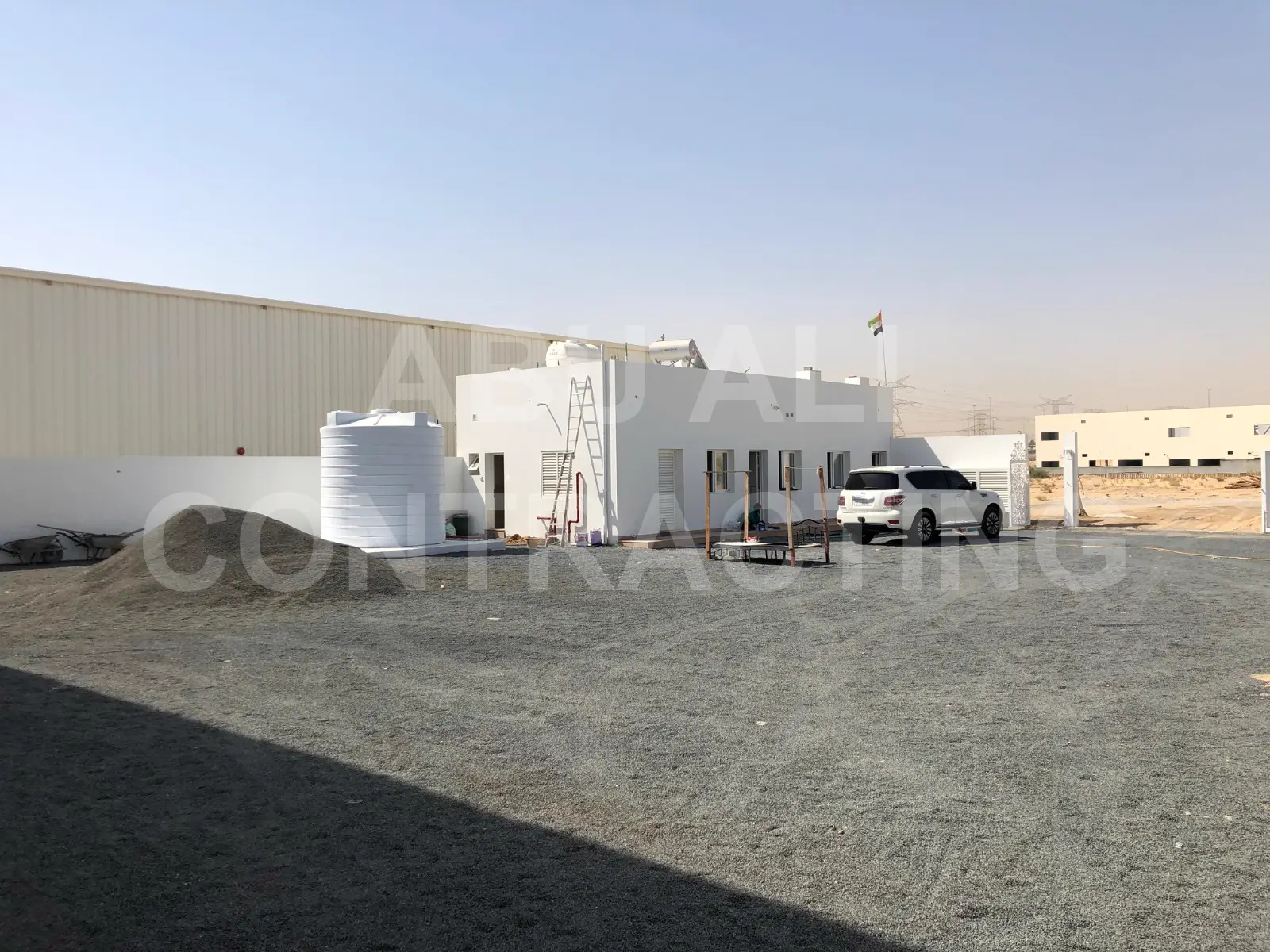 Warehouse compound showing the completed steel shed alongside the site office building and yard