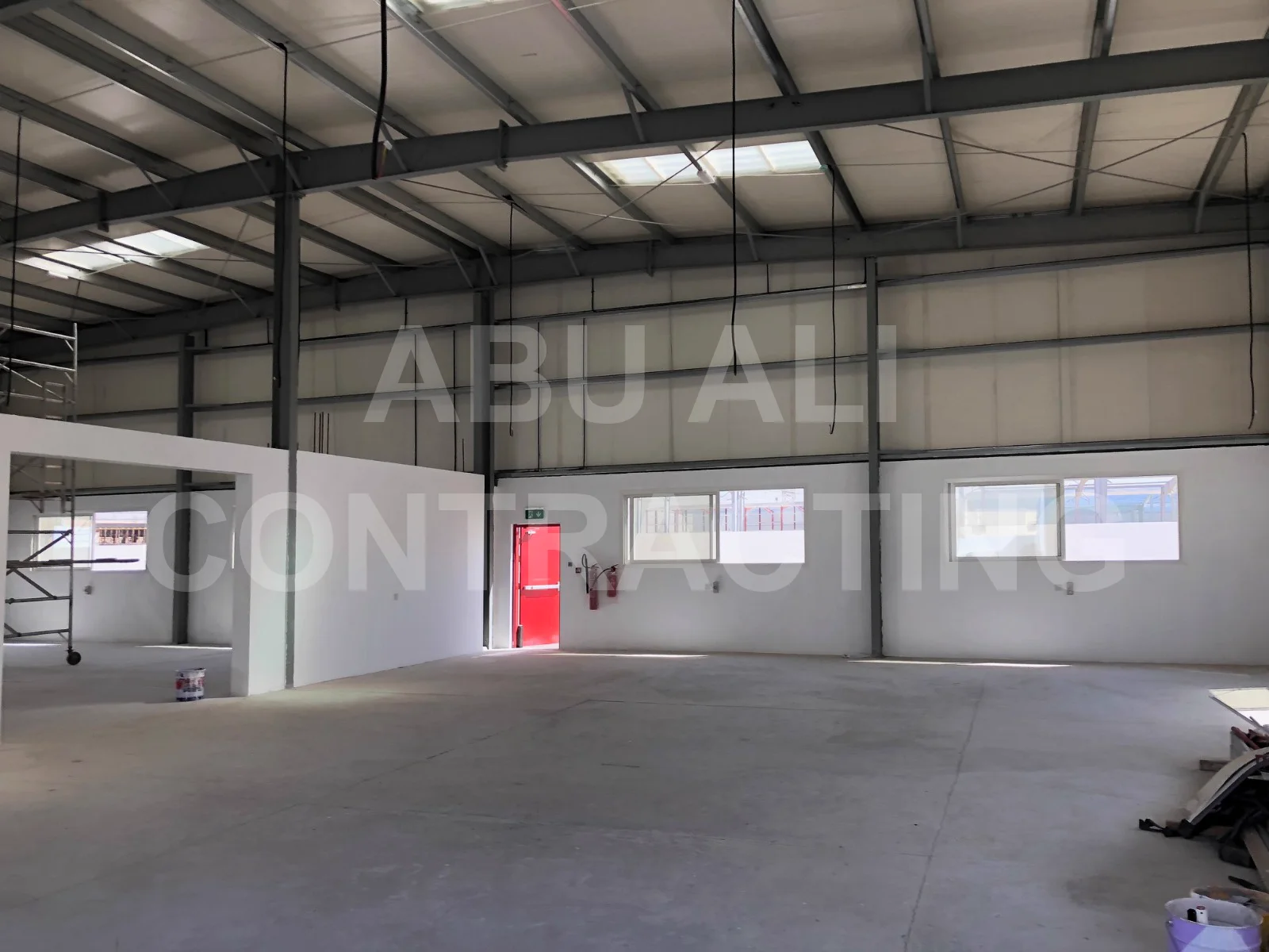 Warehouse interior at Al Ttay, Dubai with integrated office partition, fire-rated exit door and glazed windows